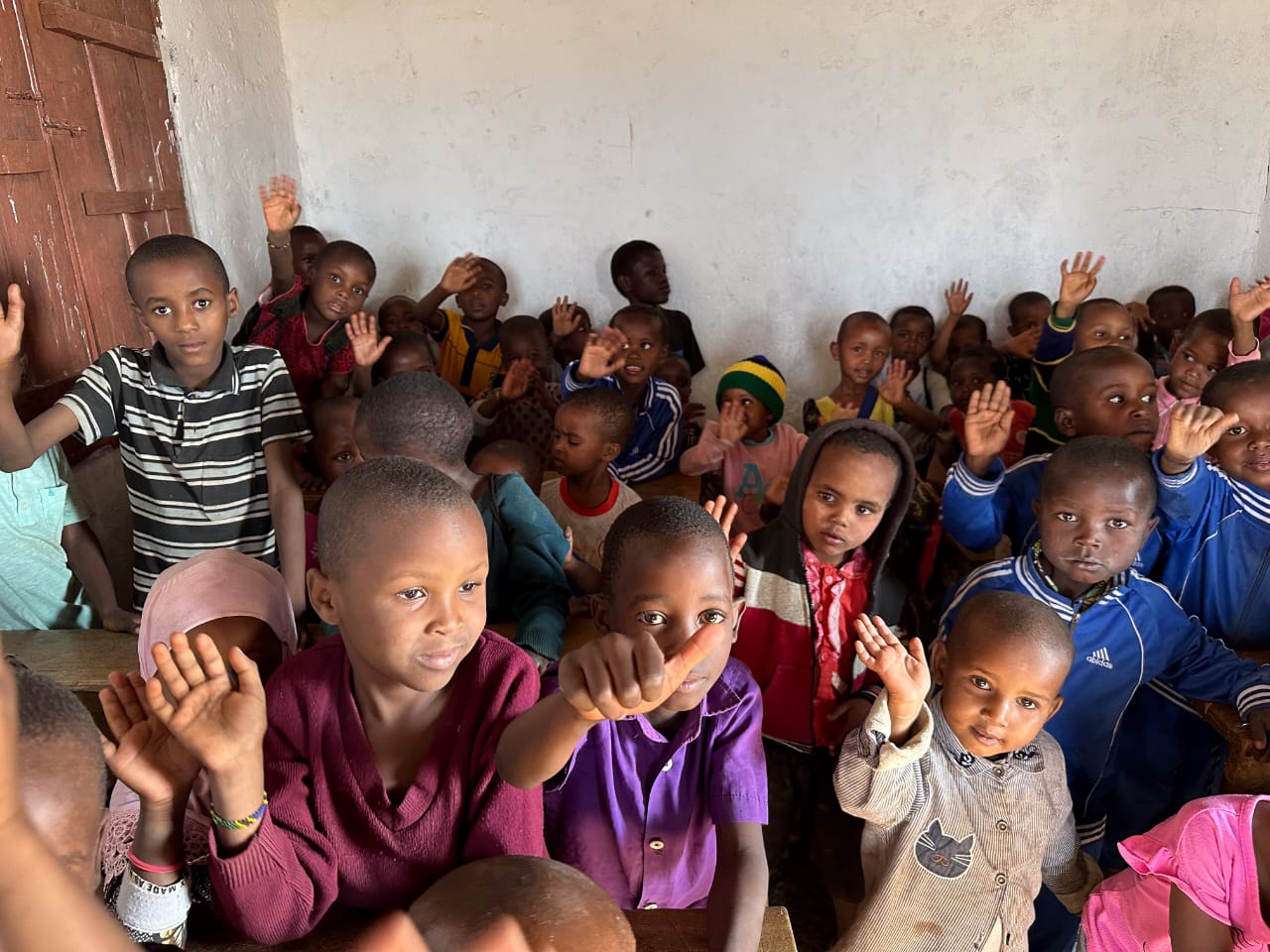 Children waving to the camera, photo shared by Martha